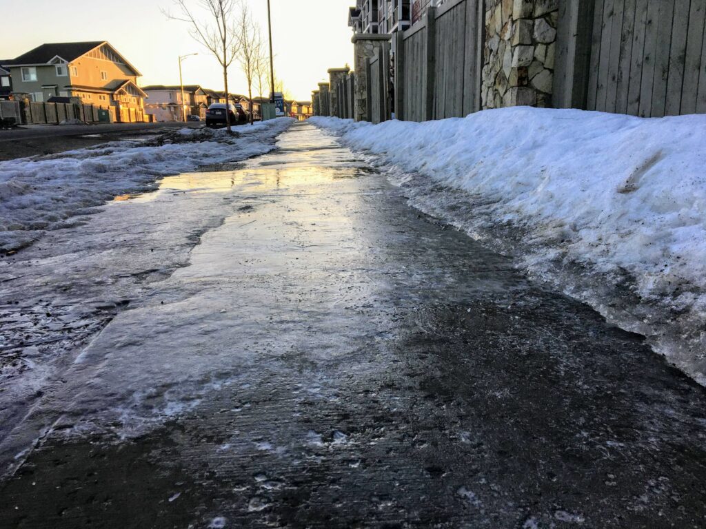Picture of an icy and snowy sidewalk.